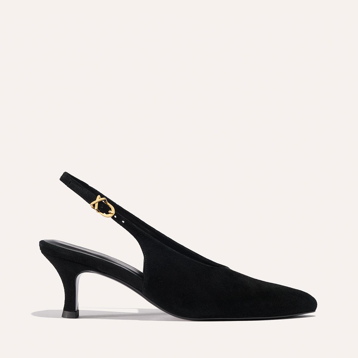 The Prado Sling - Black Suede by margaux-development is a pointed-toe slingback pump with a mid-height heel and a thin strap with a gold buckle, shown on a plain light background.