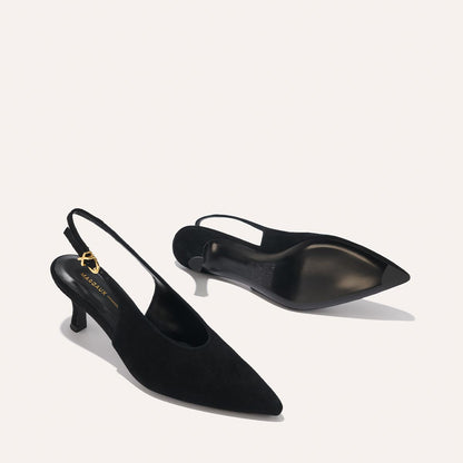 The Prado Sling - Black Suede by margaux-development: a pair of black suede, pointed-toe slingback heels with low kitten heels shown on a light background—one displays the insole and strap, the other reveals the sole.