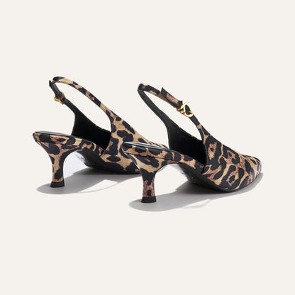 The Prado Sling - Leopard Satin by margaux-development: women’s slingback heels with a leopard satin pattern, pointed toes, black soles, and gold buckle ankle straps.