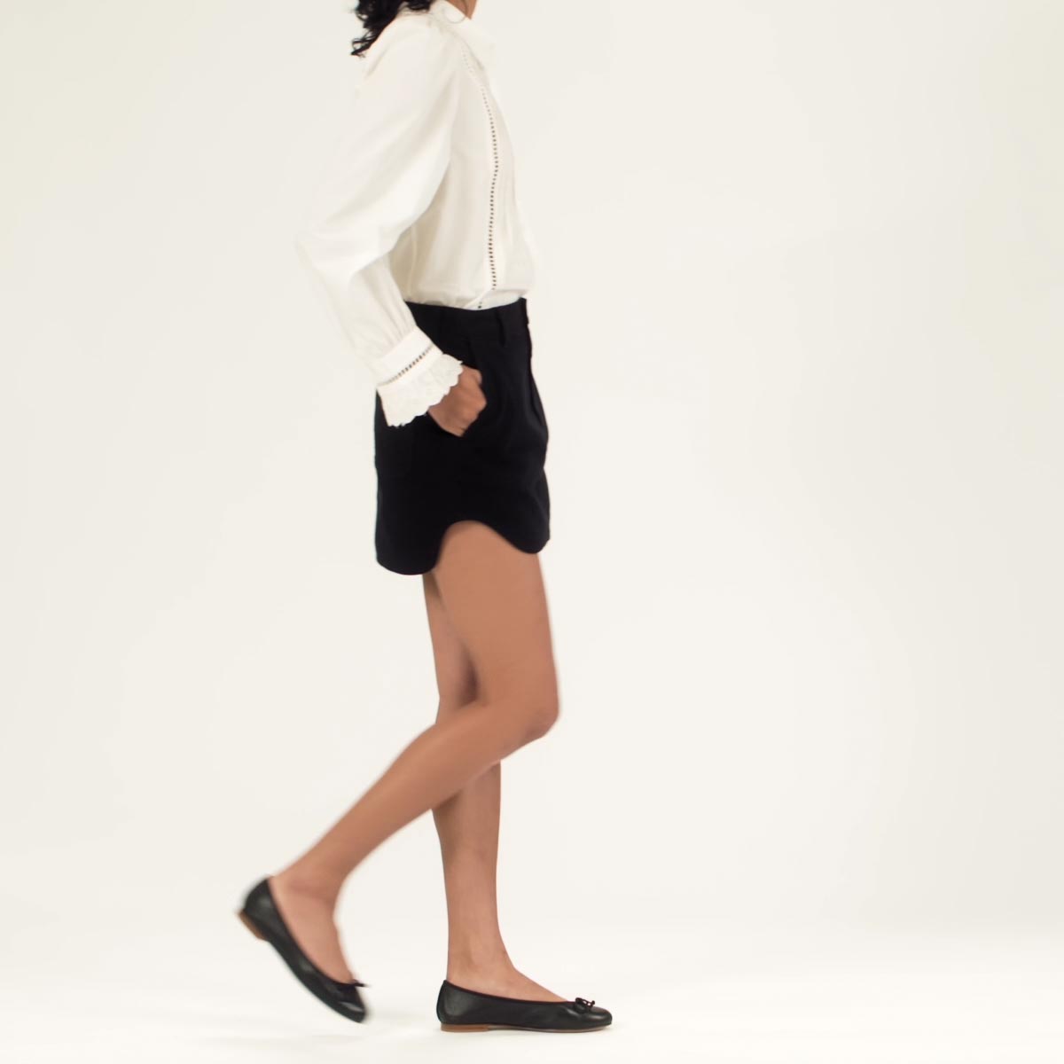 The Demi in Black Nappa shown on model styled with a black mini skirt and a white blouse.