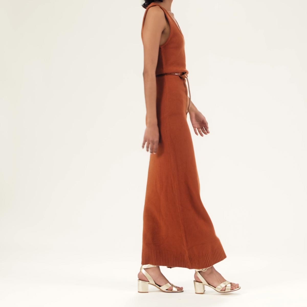 The City Sandal in Champagne Nappa shown on model styled with an orange knit sleeveless maxi dress belted around the waist.