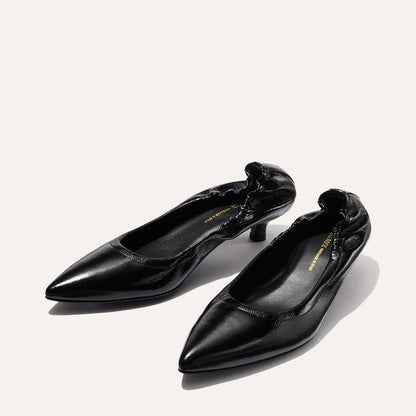 The Roma 40 - Black Crinkle Patent by Margaux features black, pointed-toe high heels with a ruched edge detail, shown on a light background.