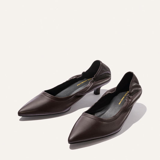 A pair of Margaux’s The Roma 40 – Espresso Nappa shoes, featuring a dark brown shade, pointed toe, low heel, and slightly ruched sides reminiscent of the chic Roma silhouette, displayed on a light background.