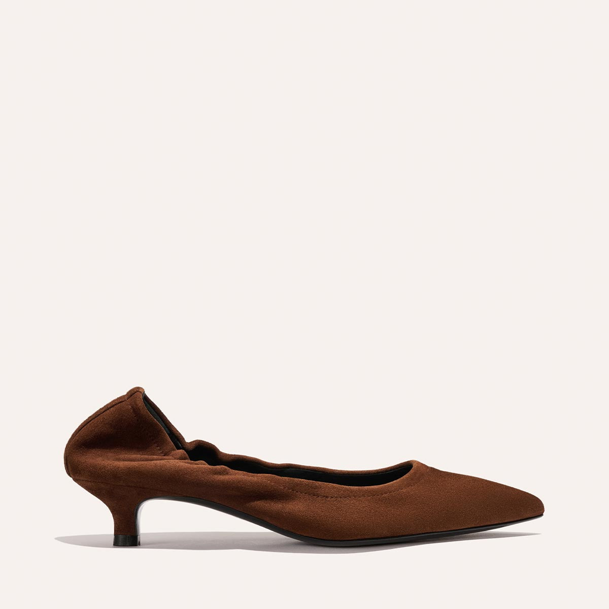 The Margaux "The Roma 40 - Ganache Suede" is a brown suede kitten heel shoe with a gently ruffled edge along the opening, a pointed-toe flat silhouette, and a comfortable low heel, shown against a simple light background.