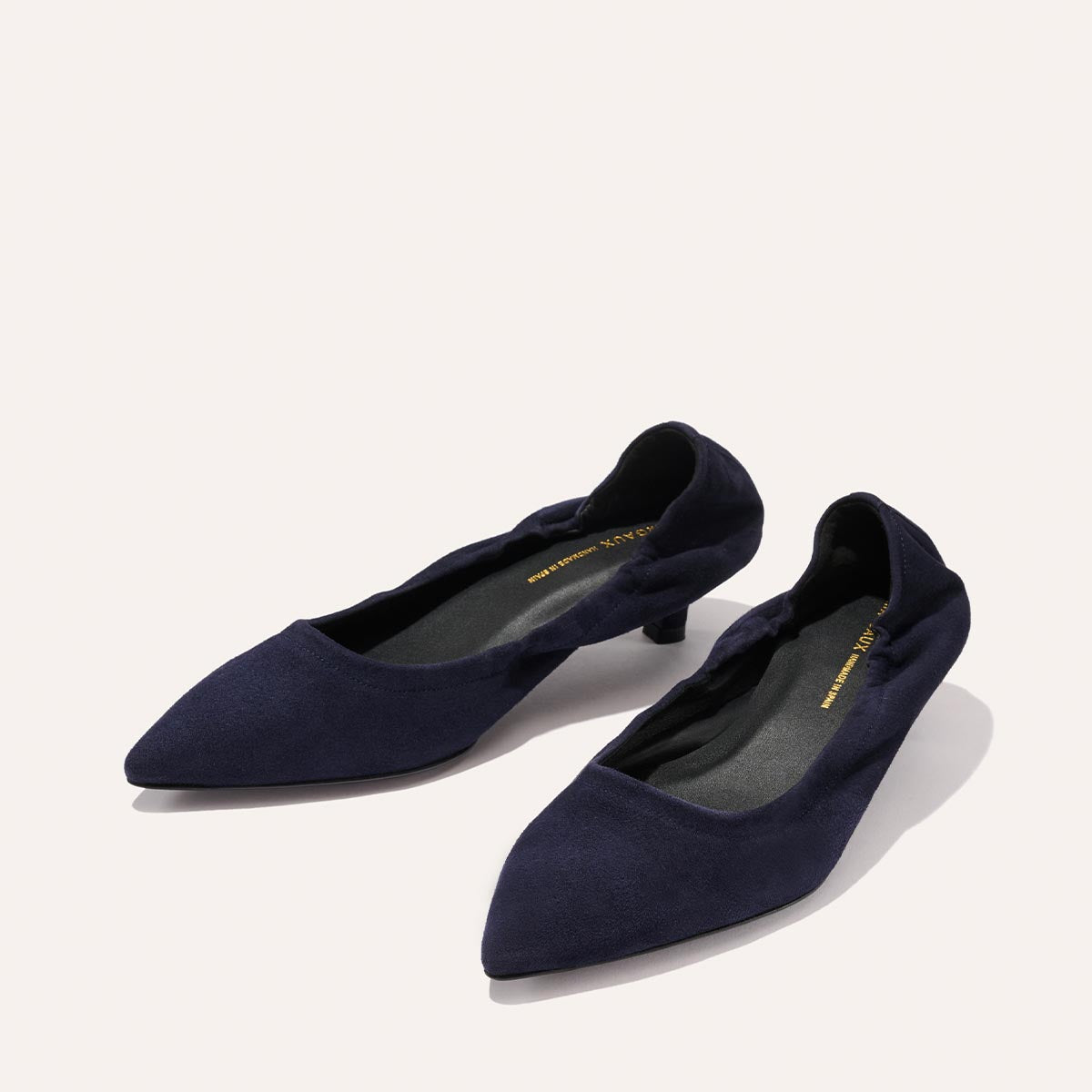 A pair of Margaux's The Roma 40 - Indigo Suede women's shoes with a soft, suede-like finish and a comfortable low heel, showcasing a pointed-toe flat silhouette in deep indigo, displayed on a light background.