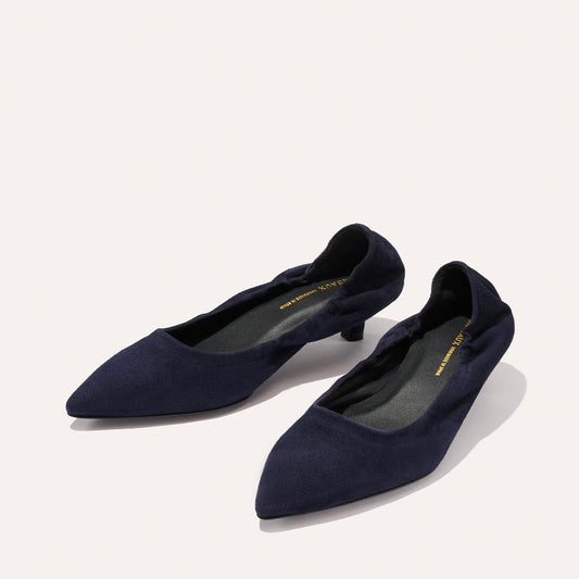 A pair of Margaux's The Roma 40 - Indigo Suede women's shoes with a soft, suede-like finish and a comfortable low heel, showcasing a pointed-toe flat silhouette in deep indigo, displayed on a light background.