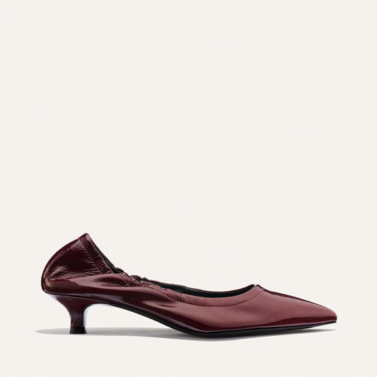 The Roma 40 - Merlot Crinkle Patent by Margaux is a maroon patent leather kitten heel shoe featuring a comfortable, walkable heel, ruched back detail, and a sleek pointed toe, shown against a simple light background.