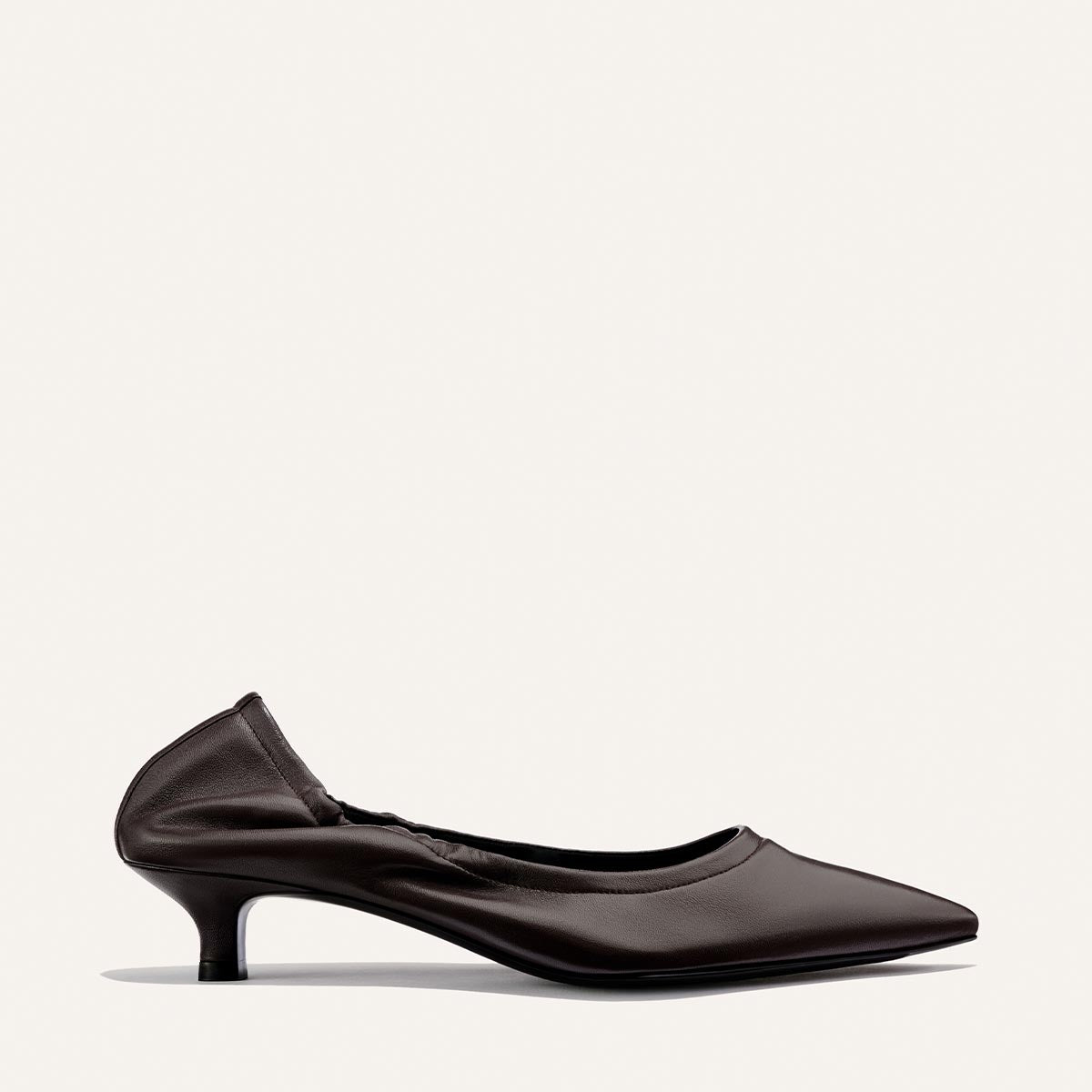 A single espresso brown leather kitten heel shoe, The Roma 40 by Margaux, featuring a chic heel and subtle gathered detail at the back, is displayed in profile against a plain white background.