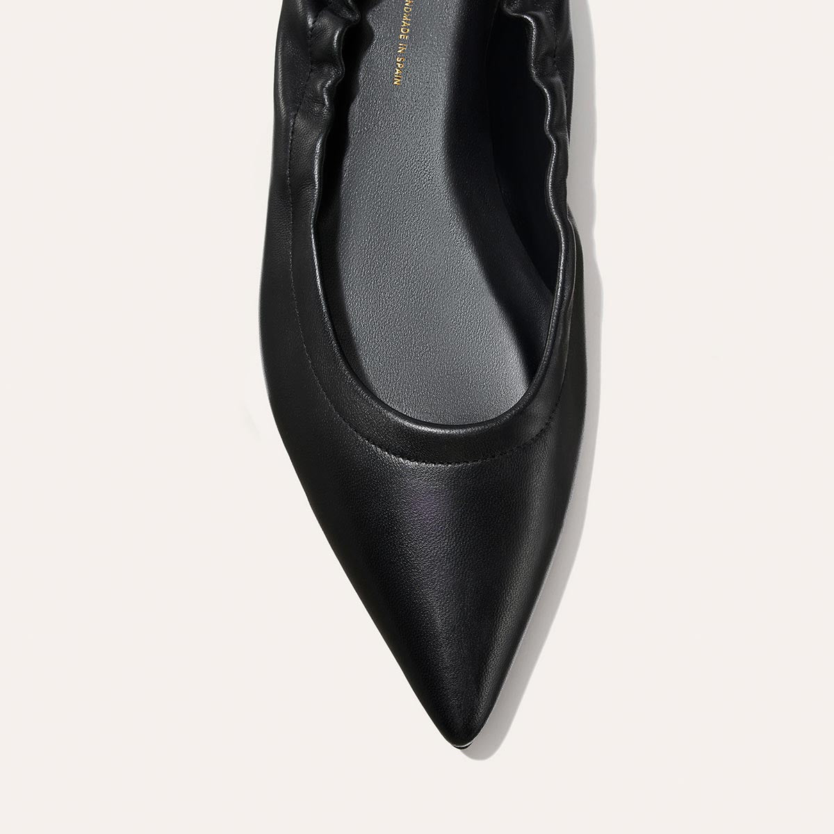 Close-up of The Roma - Black Nappa by Margaux, a pointed-toe ballet flat with gathered ruched edging, shown on a light background.