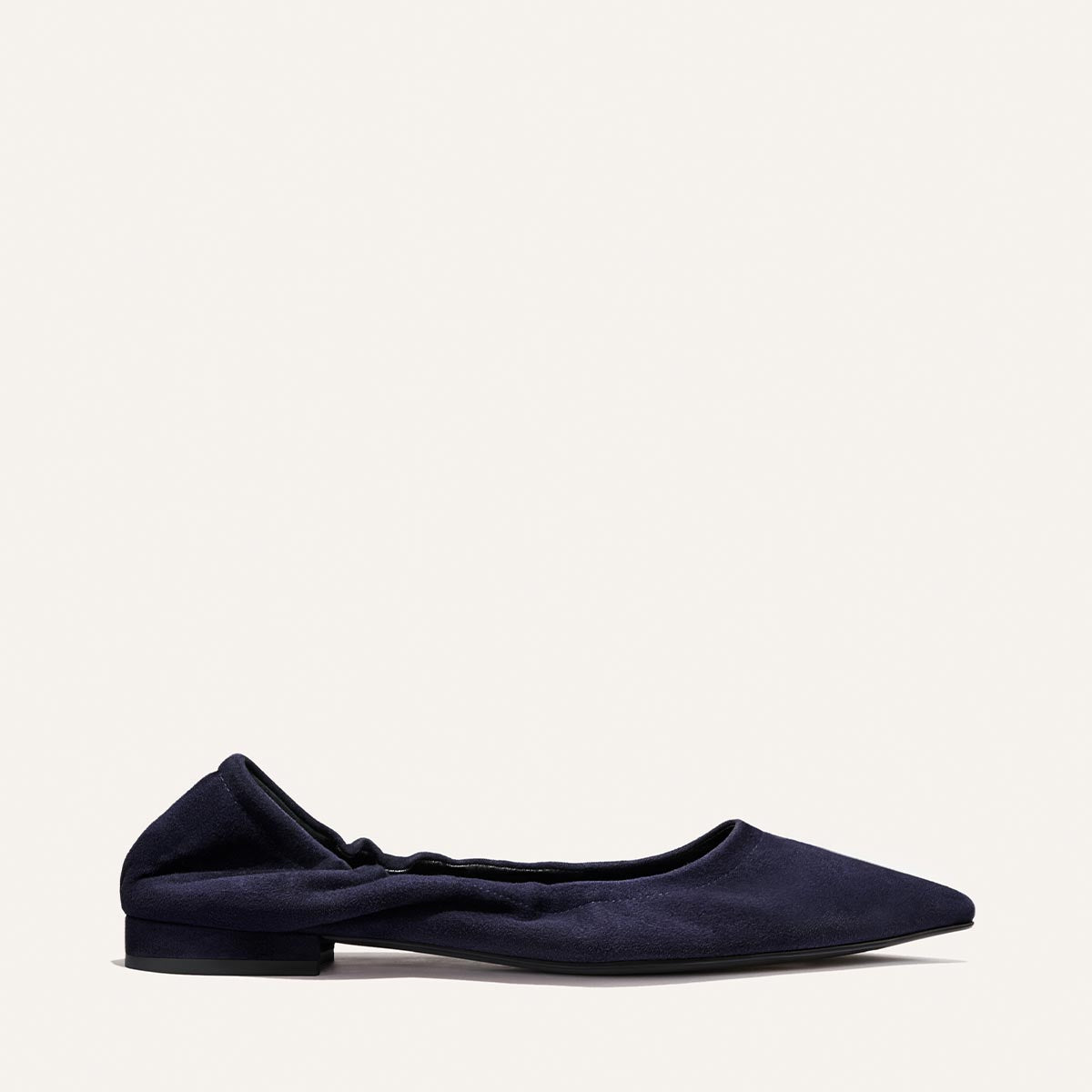 The Roma - Indigo Suede by Margaux is a single indigo suede pointed-toe ballet flat with a ruched elasticized topline and low matching heel, displayed on a neutral background, offering a sophisticated touch to any ensemble.
