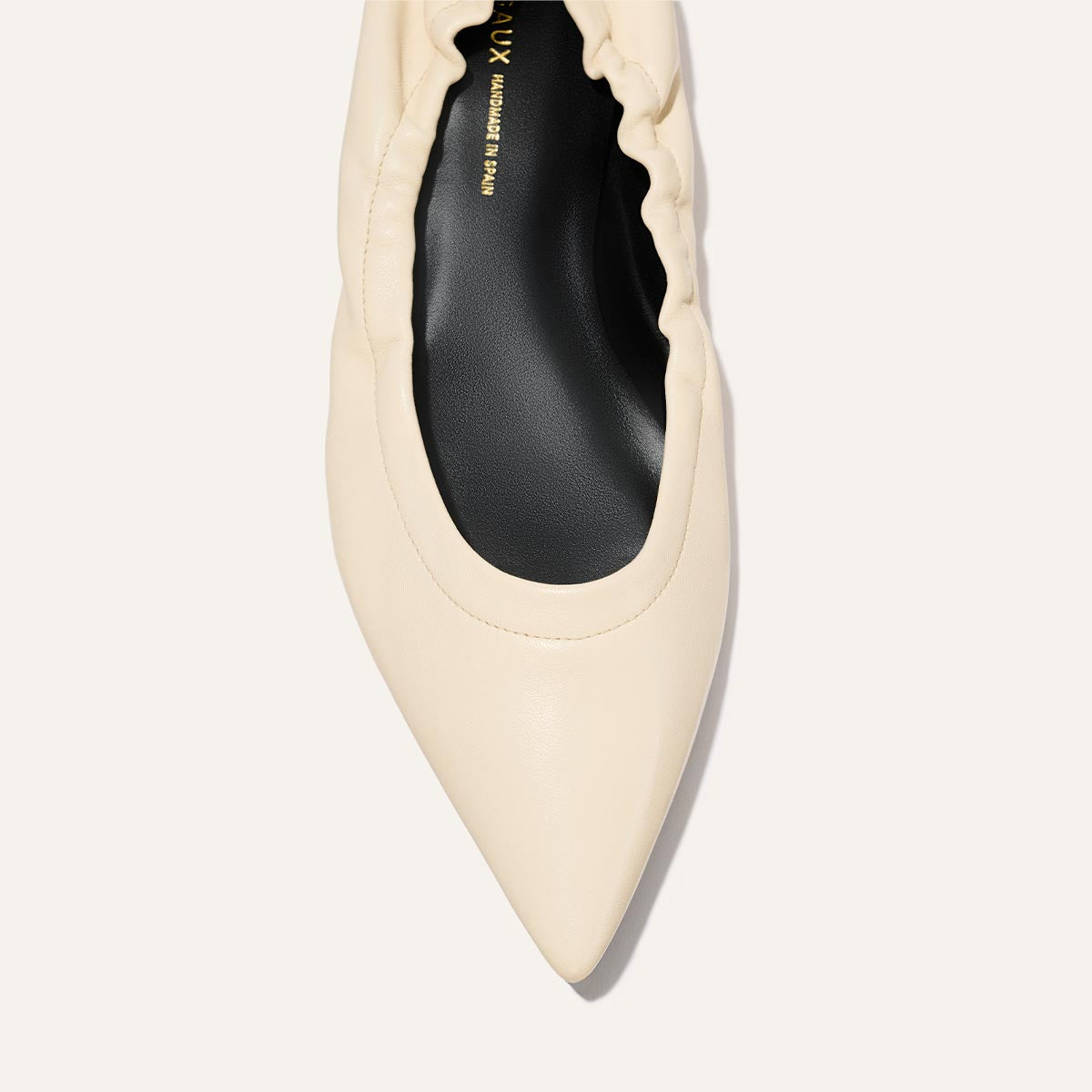 Top view of The Roma - Ivoire Nappa by Margaux: a sophisticated cream ballet flat with a pointed toe, gathered ruched edge, and black insole.