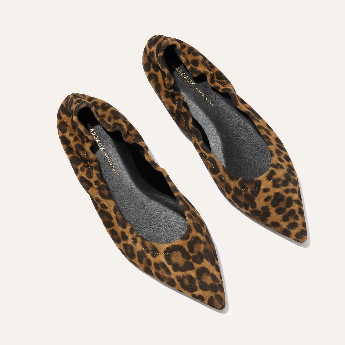The Roma - Leopard Suede by Margaux are pointed-toe ballet flats with a scrunched edge and stylish brown and black leopard print on a light suede background for comfort and flair.