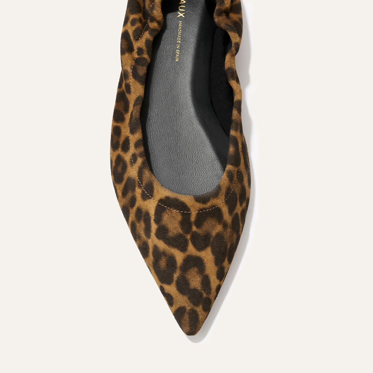 A close-up of The Roma - Leopard Suede by Margaux, a pointed-toe ballet flat in brown and black leopard print on a light background, blending style with comfort.