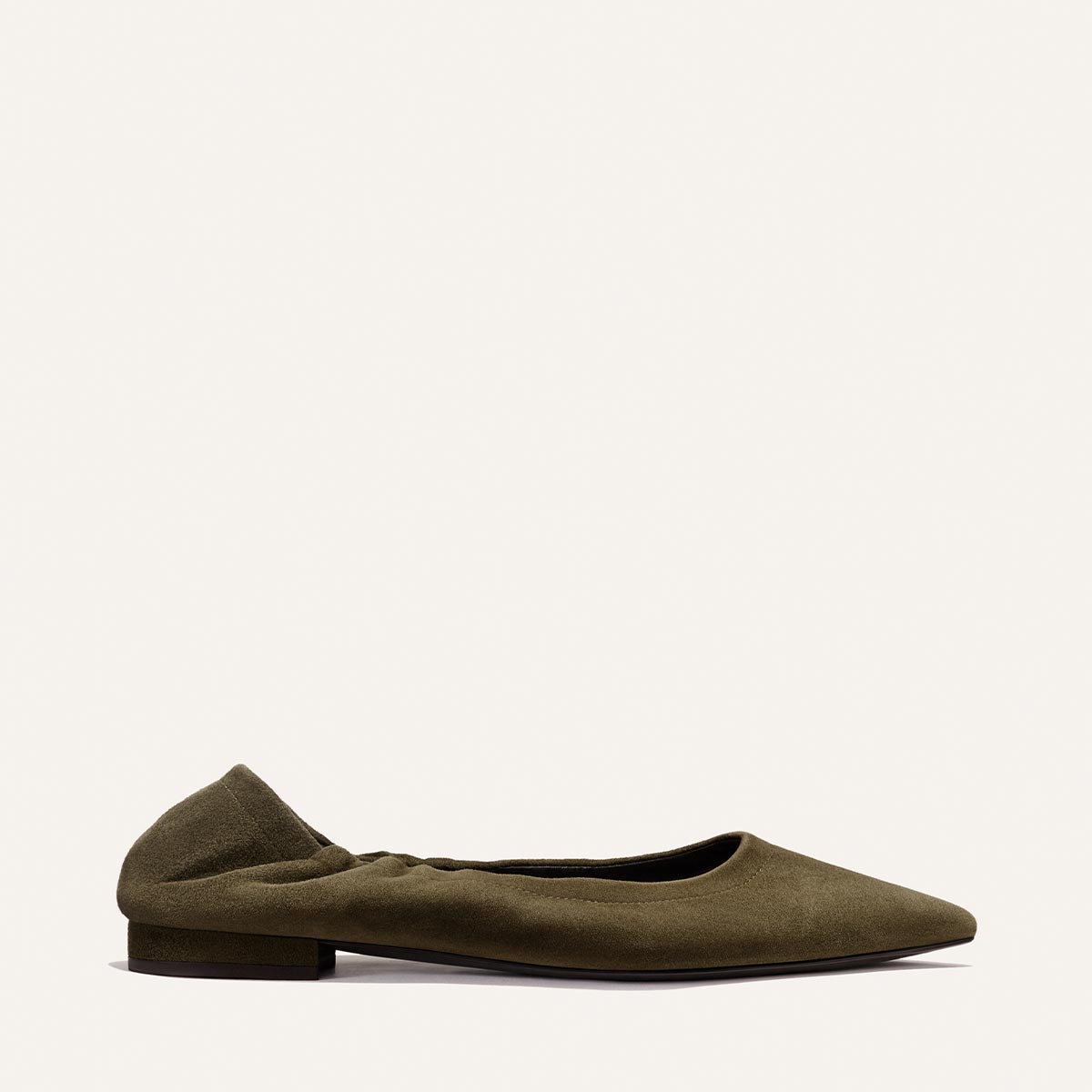 The Roma - Moss Suede by Margaux is a single olive green flat shoe crafted from suede, featuring a low heel and gently ruched sides, displayed against a plain white background.