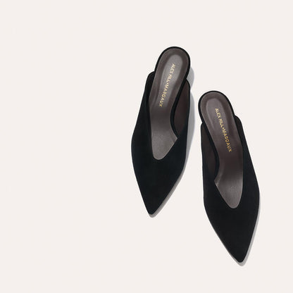 The Alex Mill x Margaux: The Romy - Black Suede features black pointed-toe kitten mules with a low heel, ideal for parties. "Margaux" is printed in gold on the insole, shown against a light beige background.