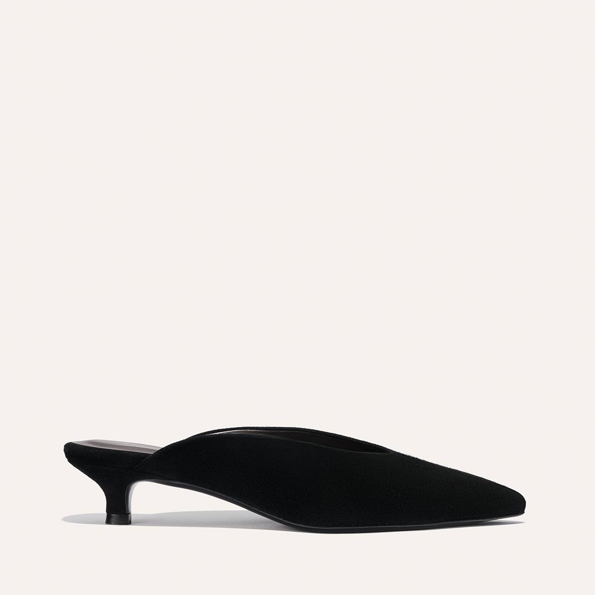 The Romy - Black Suede by Margaux is a black suede kitten mule with a pointed toe and low, slim heel, pictured in profile on a plain light background—an elegant option from the Alex Mill x Margaux collection.
