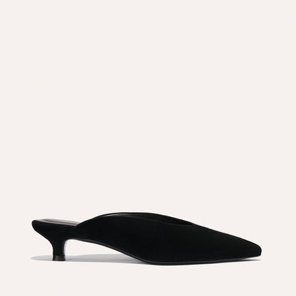 The Romy - Black Suede by Margaux is a black suede kitten mule with a pointed toe and low, slim heel, pictured in profile on a plain light background—an elegant option from the Alex Mill x Margaux collection.
