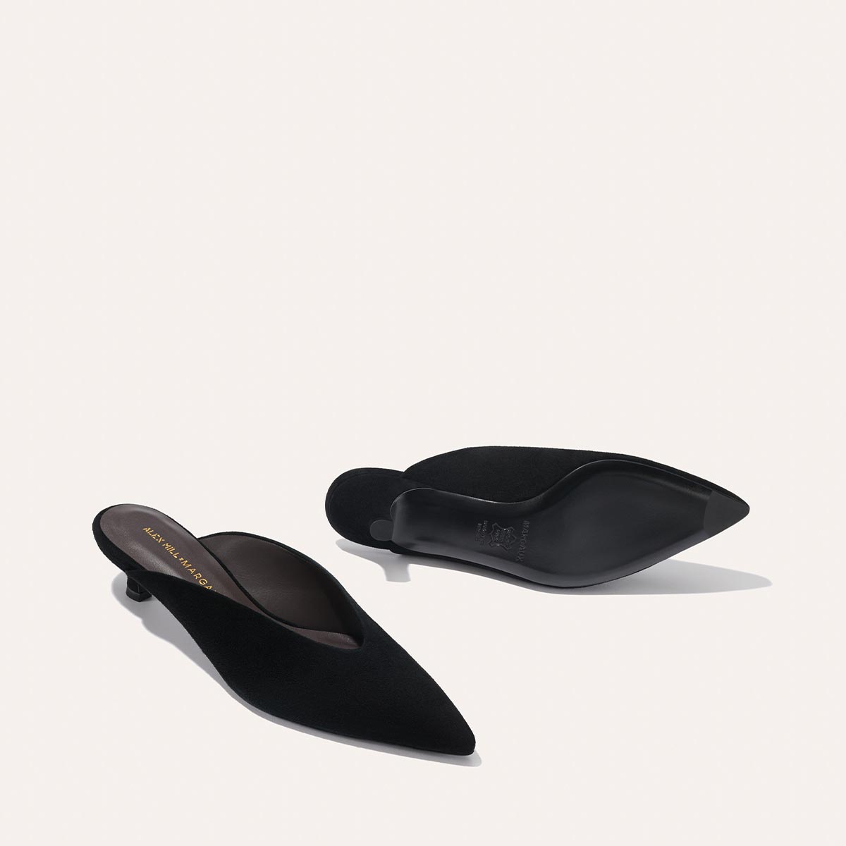 The Margaux Alex Mill x Margaux: The Romy - Black Suede features sleek pointed-toe kitten heels, elegantly displayed on a light background—an ideal party shoe with timeless style.