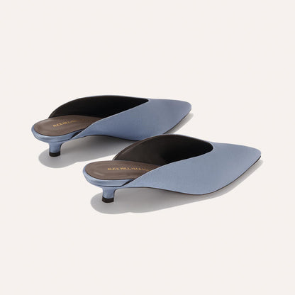 The Margaux Alex Mill x Margaux: The Romy - Slate Blue Satin is a chic, comfortable pointed-toe kitten mule with low heels and dark insoles, shown on a light background—perfect for effortless party style.