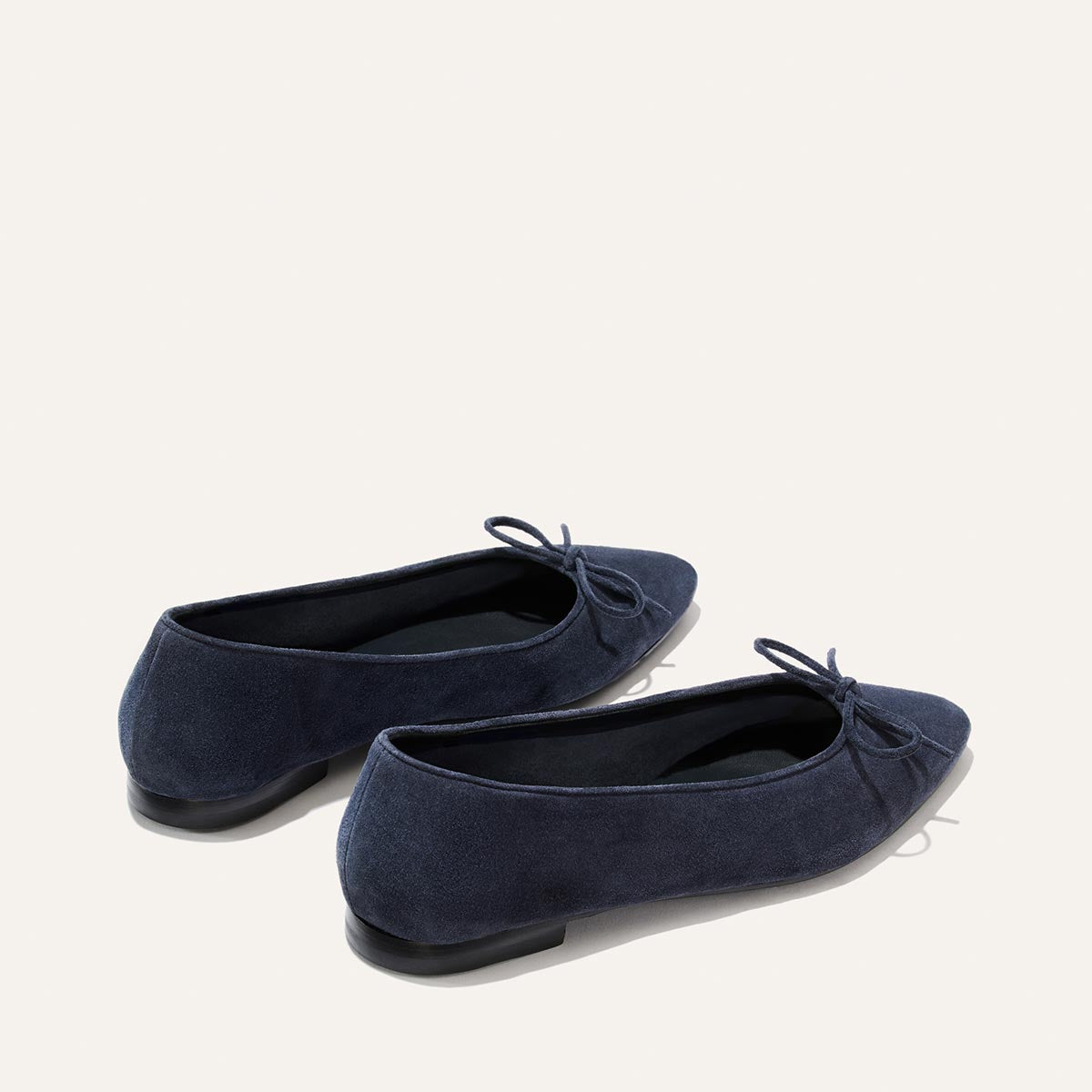 The Salamanca - Vintage Navy Suede ballet flats feature an unlined navy suede construction, a pointed toe, and a small decorative bow.