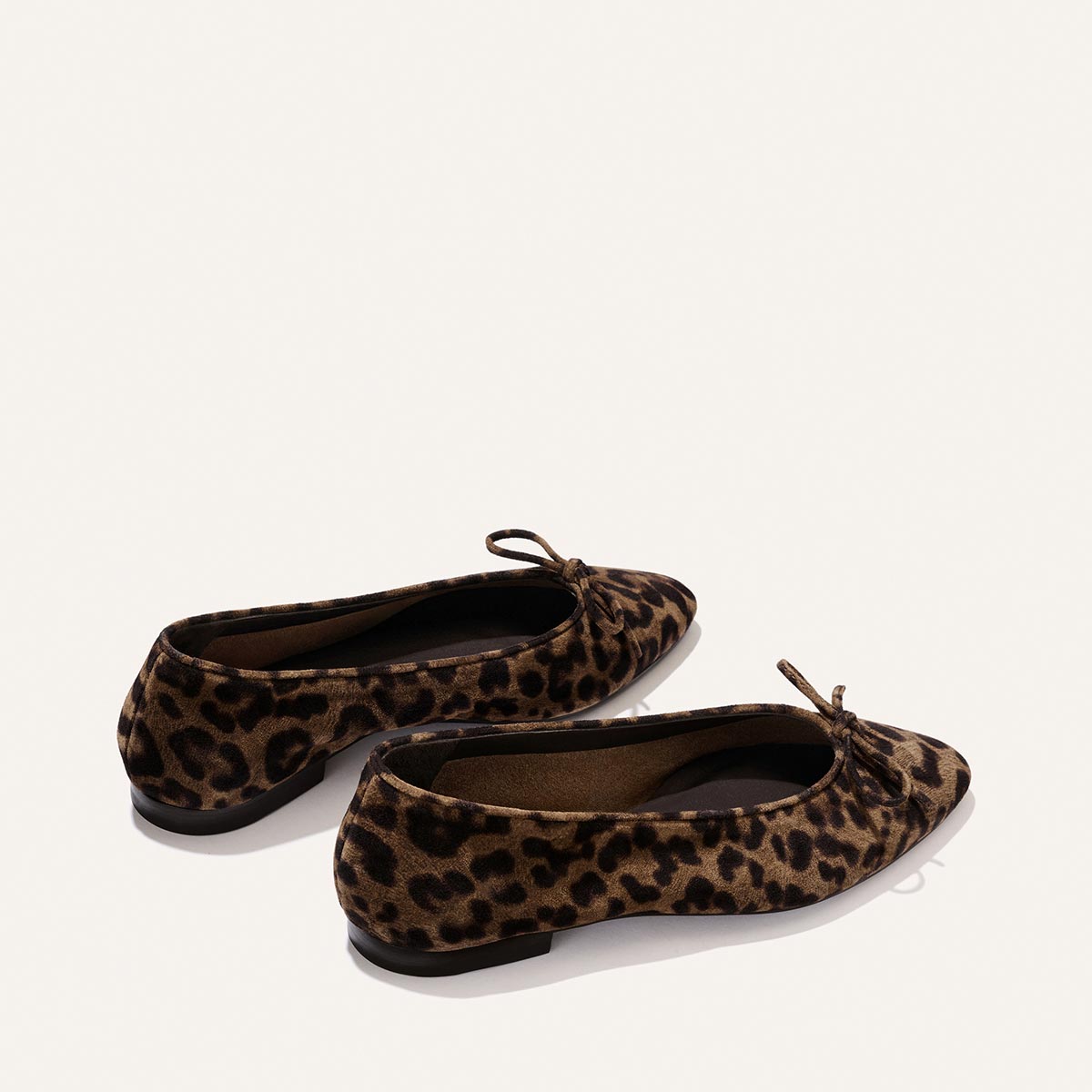 The Salamanca - Brown Leopard Suede by Margaux: pointed-toe ballet flats in leopard print suede, featuring small front bows, shown on a plain light background.