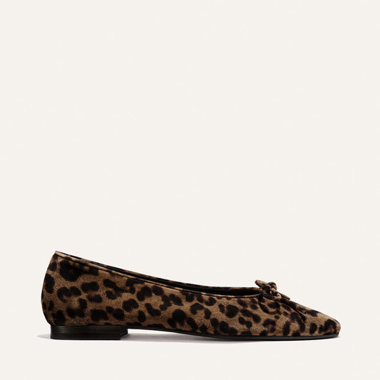 The Salamanca - Brown Leopard Suede by Margaux is a single ballet flat featuring luxurious brown suede with a black leopard print, a low black heel, and a delicate bow on the front, displayed against a plain off-white background.
