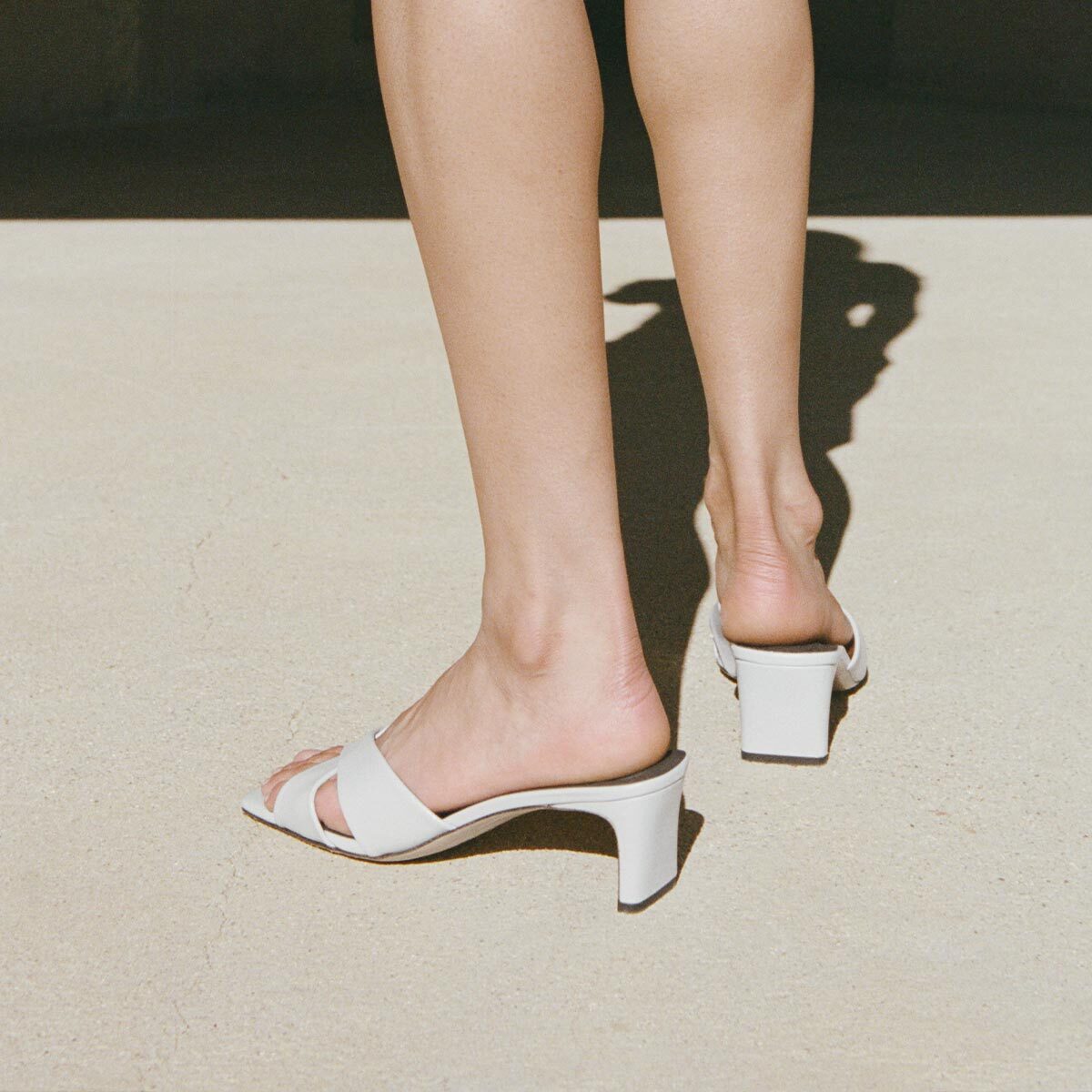 Light blue sandals worn on feet with a neutral background