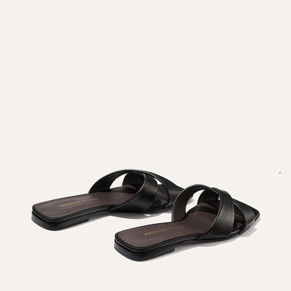 The Selene Flat Sandal by Margaux features black nappa leather, crisscross straps, flat soles, and square toes. Displayed on a plain white background.