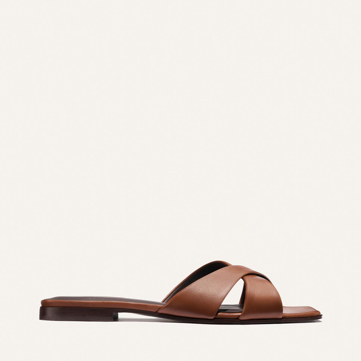 Brown sandal with criss-cross straps on a white background