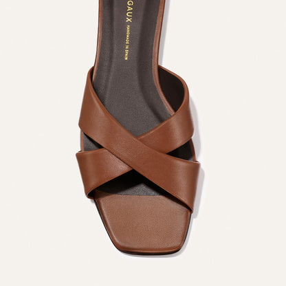 Brown sandal with criss-cross straps on a white background