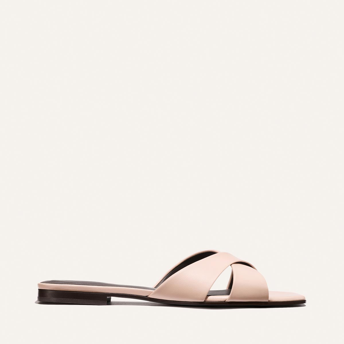 Light pink sandal with a black sole on a white background