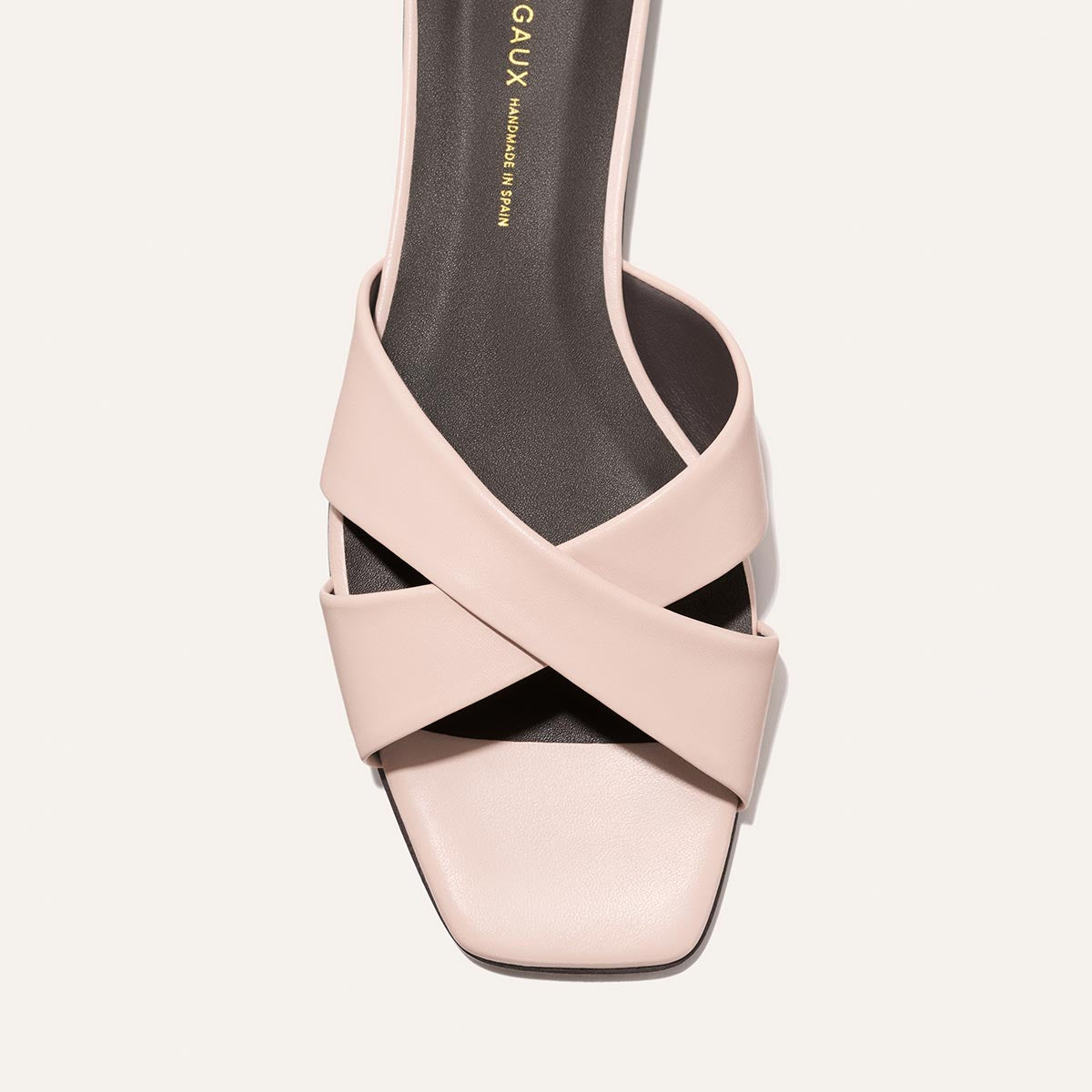 Pink sandal with criss-cross strap design on a white background