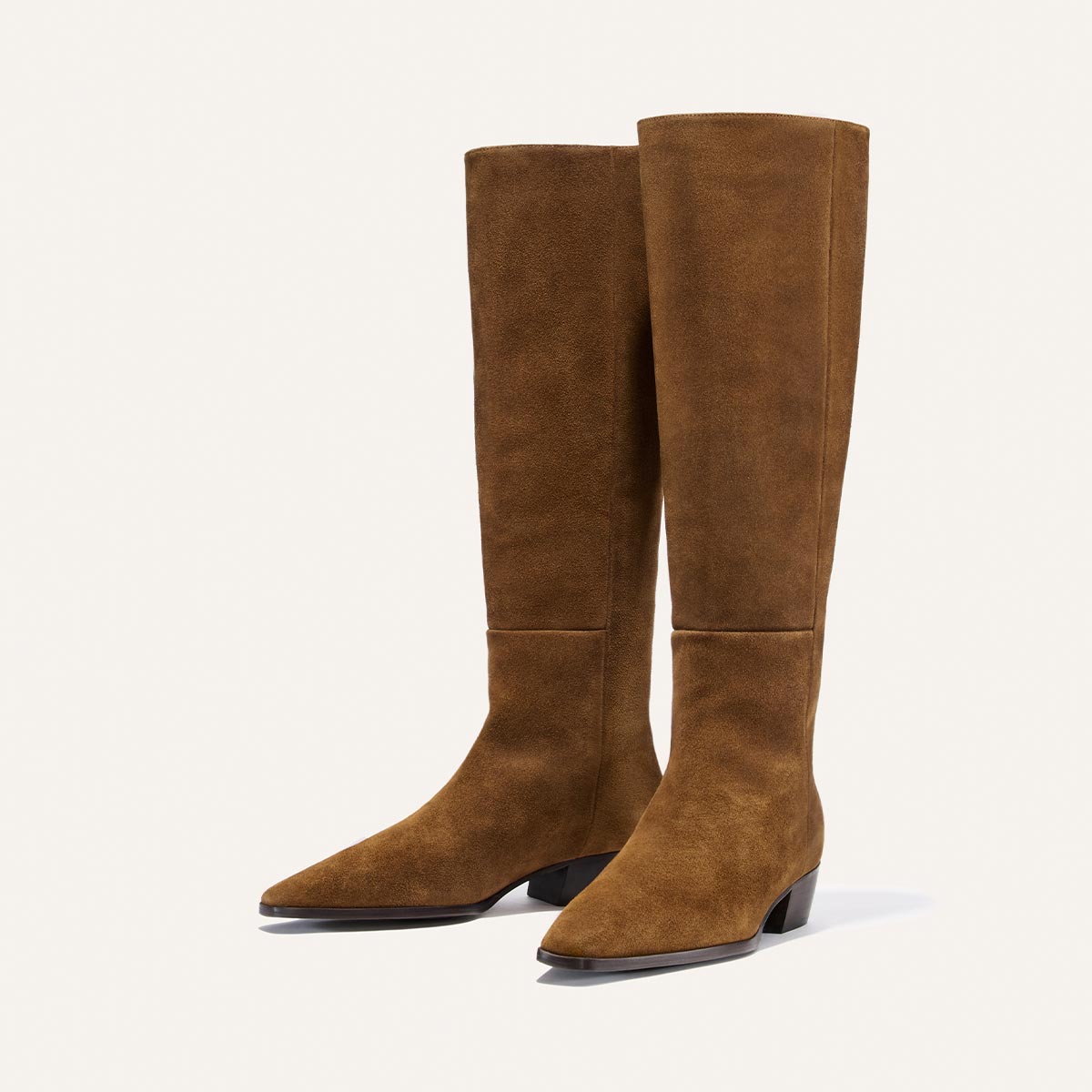 A pair of Margaux’s The Sierra Knee-High Boots in Cedar Suede, featuring pointed toes and low block heels, are displayed on a plain light background.