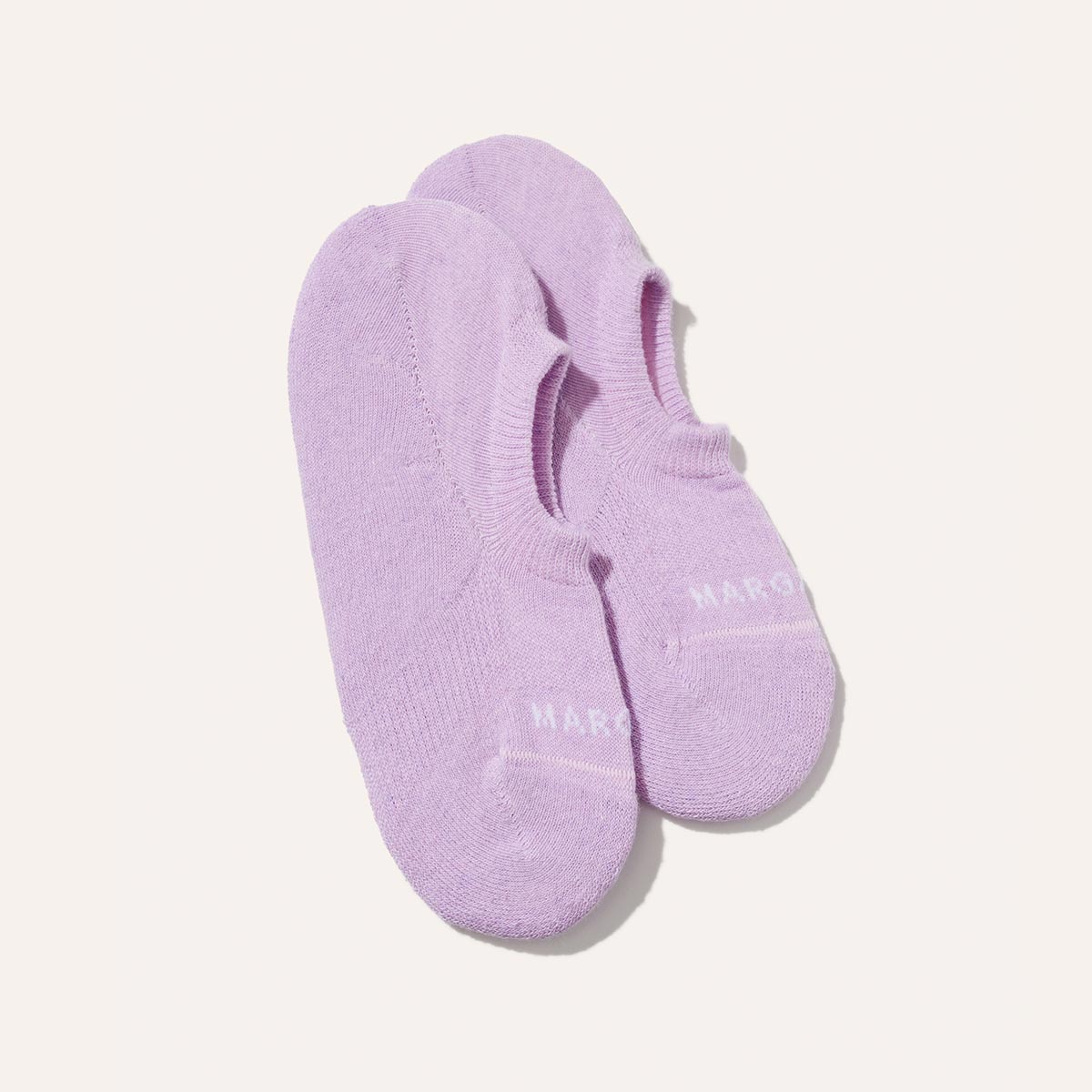 The Sneaker Sock - Wisteria by Margaux: a pair of lavender no-show socks with white toe text and non-slip grips, shown on a plain white background.