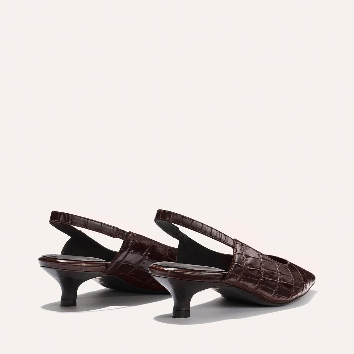 The Sofia Sling - Espresso Croc Embossed by Margaux is shown at an angle, highlighting its textured crocodile embossing and micro kitten heel against a plain light background.