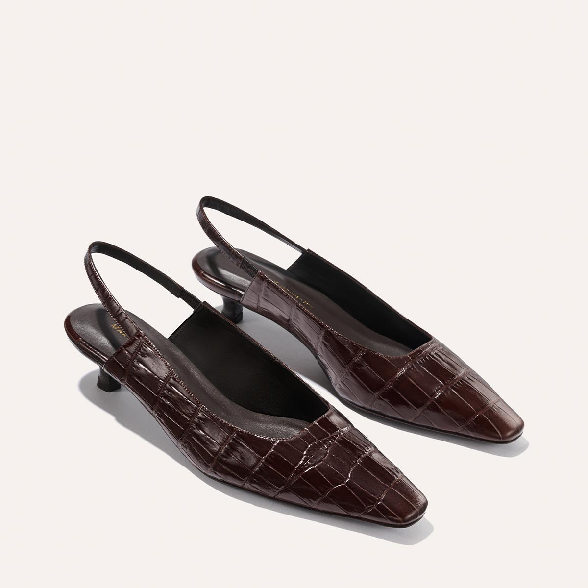 The Sofia Sling - Espresso Croc Embossed by Margaux features dark brown, crocodile-embossed leather, a chic micro heel, and snip-toe design, elegantly displayed against a light background.