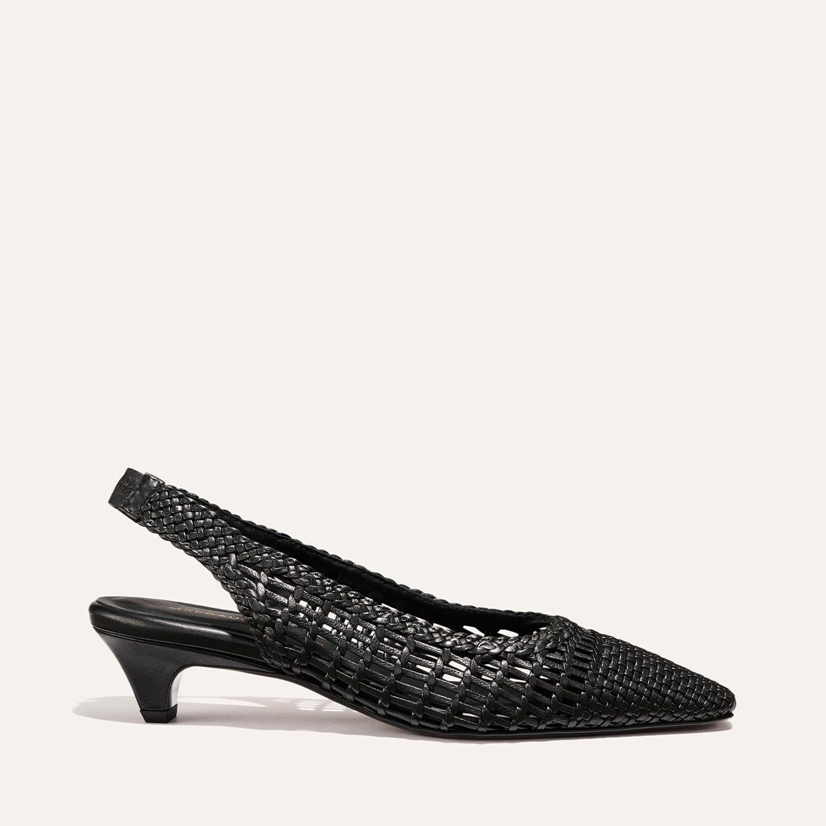 The Sofia Sling by Margaux is a black woven leather slingback pump featuring a pointed toe and low kitten heel, shown against a plain light background.
