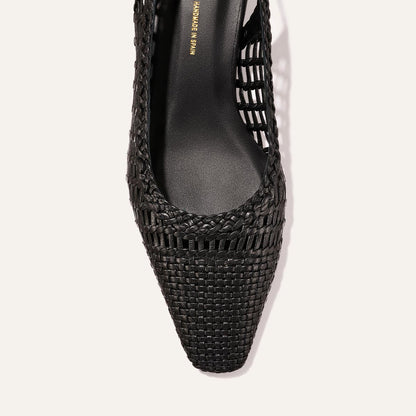 Close-up of The Sofia Sling by Margaux in black woven leather, featuring a pointed square toe and cutout sides, viewed from above on a light background.