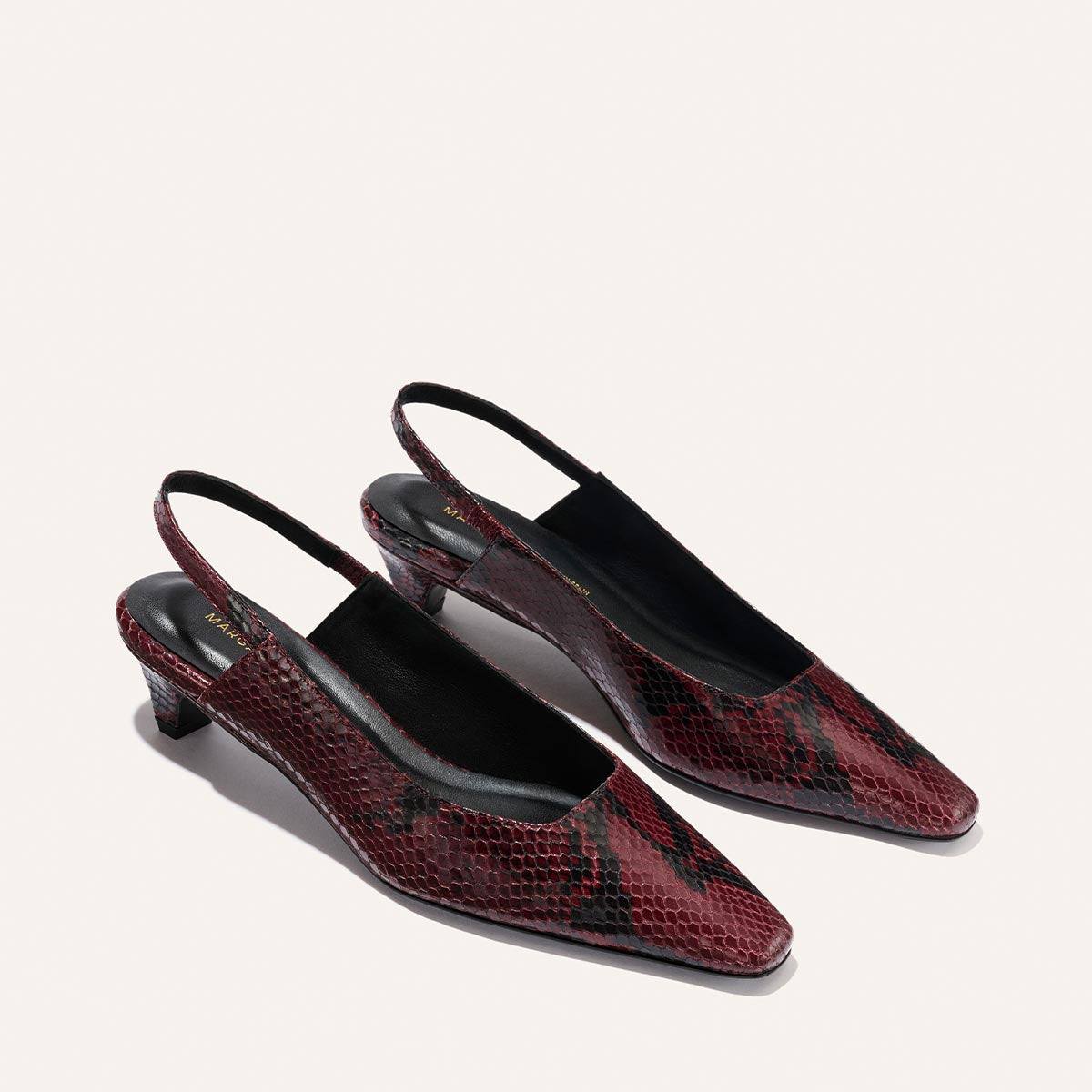 The Sofia Sling - Burgundy Python Embossed by Margaux: a pair of pointed-toe, red and black snakeskin-patterned slingback heels with low square heels, showcased on a light background.