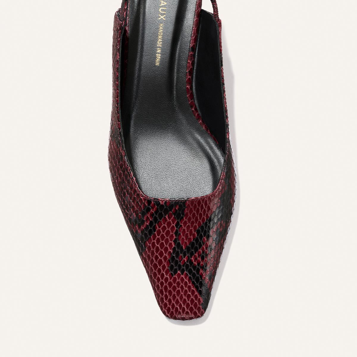 The Sofia Sling by Margaux features a pointed toe, burgundy python-embossed pattern, black insole, and elegant slingback design.