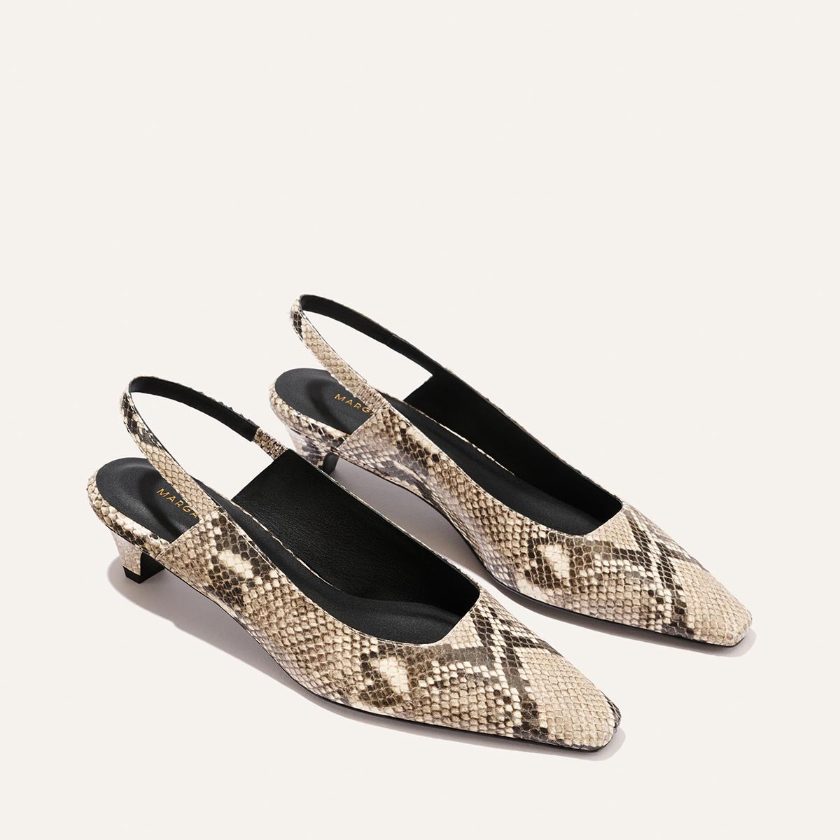 The Sofia Sling - Natural Python Embossed by Margaux is a pair of women’s slingback kitten heels, featuring a beige and brown snakeskin pattern, snip nose pointed toes, and a chic 1.5" heel, beautifully displayed on a plain light background.