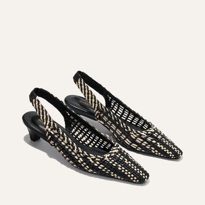 Black and white woven slingback shoes on a light gray background