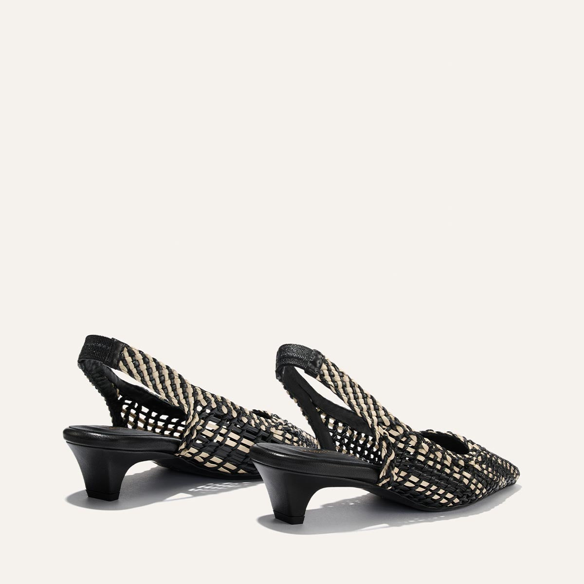 Black and gold woven slingback heels on a white background