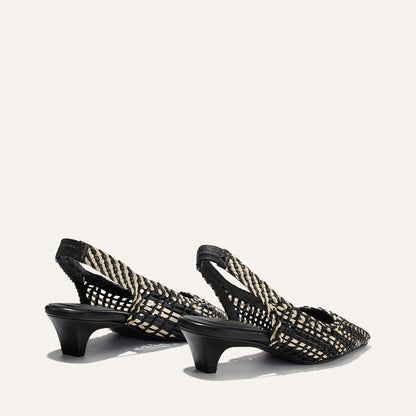 Black and gold woven slingback heels on a white background
