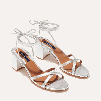 The Soho Sandal in Silver Nappa, featuring thin, flattering straps with a delicate ankle wrap, and a comfortable 2.5-inch block heel.