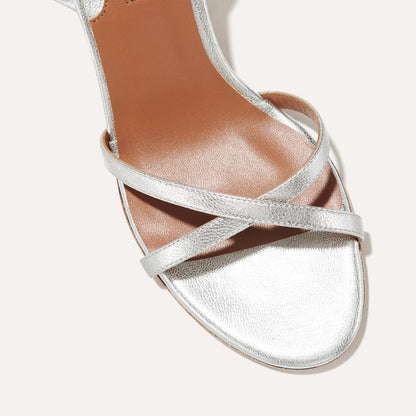 The Soho Sandal in Silver Nappa, featuring thin, flattering straps with a delicate ankle wrap, and a comfortable 2.5-inch block heel.