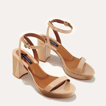 The Stella Platform in Dune Patent, featuring a sleek strap across the toes and a comfortable 3.5-inch block heel and platform.