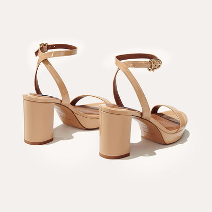 The Stella Platform in Dune Patent, featuring a sleek strap across the toes and a comfortable 3.5-inch block heel and platform.