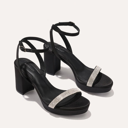 The Stella Platform in Black Satin with Crystals, featuring a sleek strap across the toes and a comfortable 3.5-inch block heel and platform.