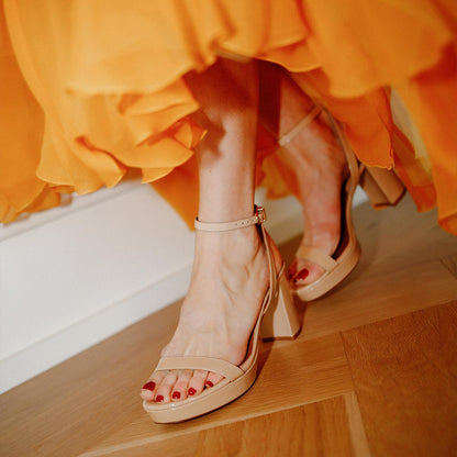 The Stella Platform in Dune Patent, featuring a sleek strap across the toes and a comfortable 3.5-inch block heel and platform.